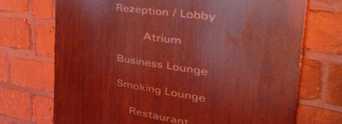 Holz-Wegweiser mit Beschriftung Rezeption, Atrium, Business Lounge, Smoking Lounge und Restaurant – Hotelausstattung von Folien-Fischer